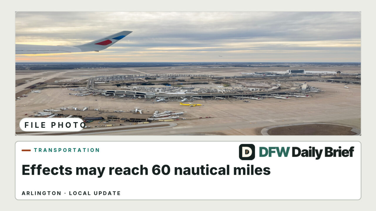 Aerial view of DFW International Airport terminals, runways and parked airplanes beneath an airplane wing; file photo.